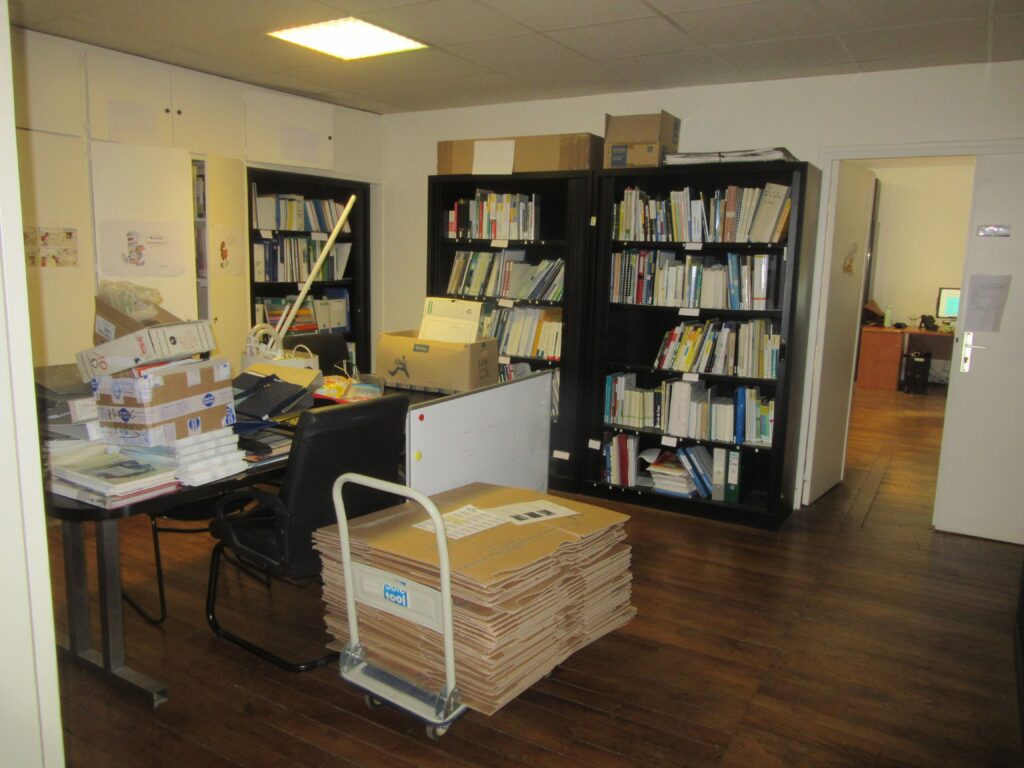 Bibliothèque, livres, documents, cartons pendant un déménagement.